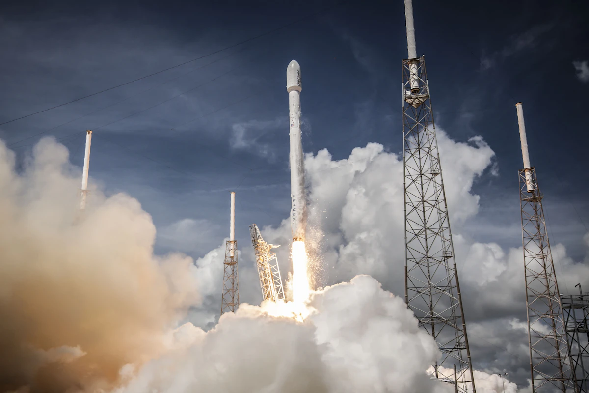 Falcon 9 climbing past the launch towers